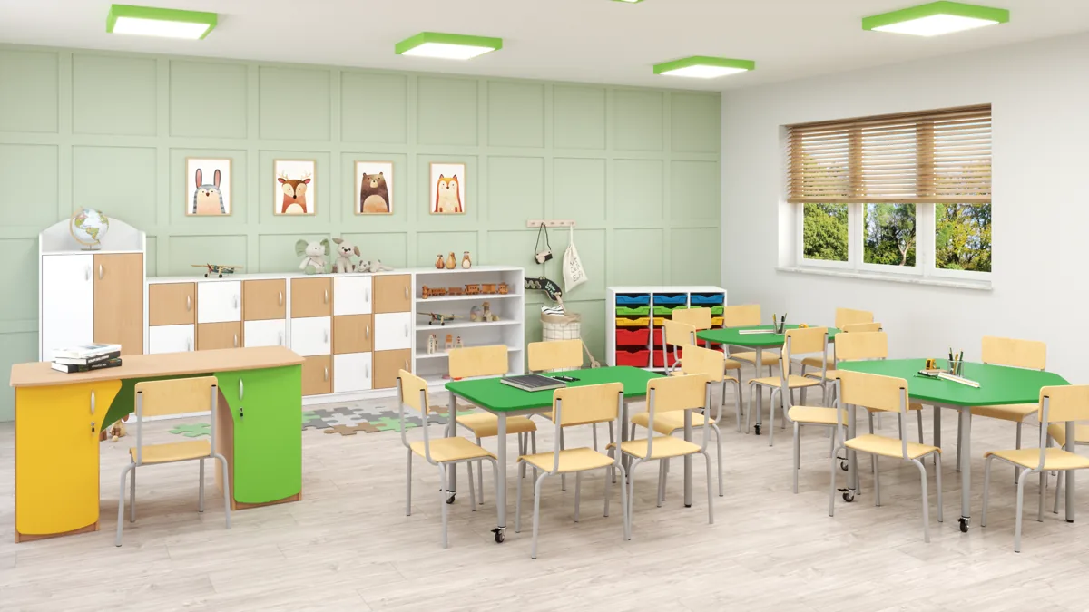 Sala przedszkolna z zielonymi stolikami, krzesełkami i szafkami z pojemnikami